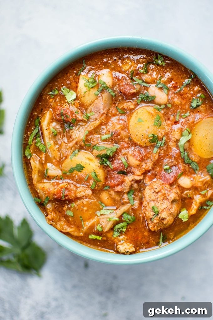 Hearty Crockpot Cabbage Soup with Sausage, Beans & Potatoes 2 Crockpot cabbage soup with potatoes, beans, and sausage in a teal bowl