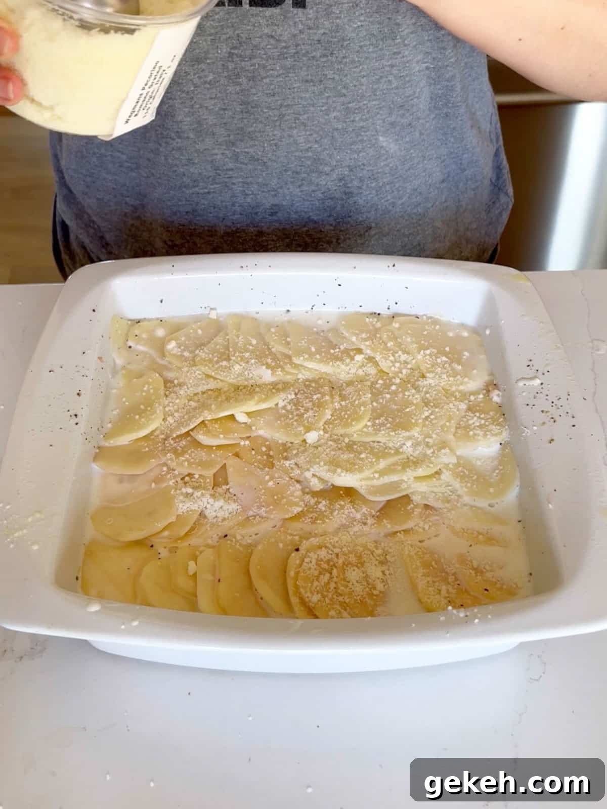 Classic Creamy Scalloped Potatoes Recipe from Mom 8 Romano cheese sprinkled on top of the potato mixture in the pan.