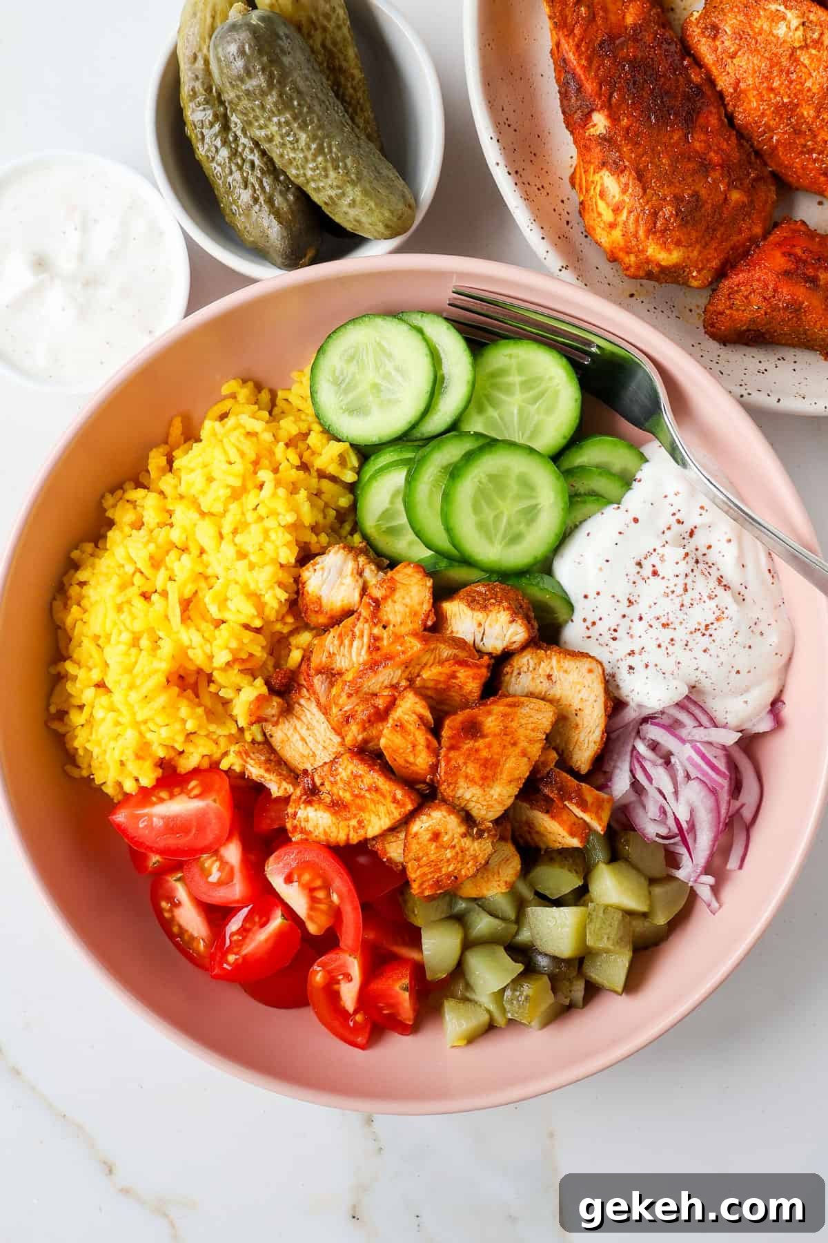 Chicken Shawarma Bowls with Garlic Sauce and Rice 2 Chicken shawarma in a bowl with turmeric rice, veggies, pickles, and yogurt sauce.
