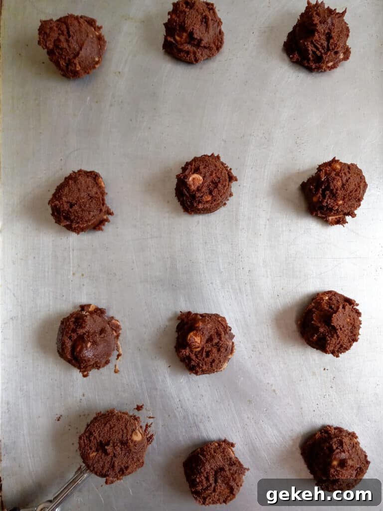 Amish Chocolate Peanut Butter Chip Cookies Recipe 3 chocolate cookie dough balls on a baking tray.