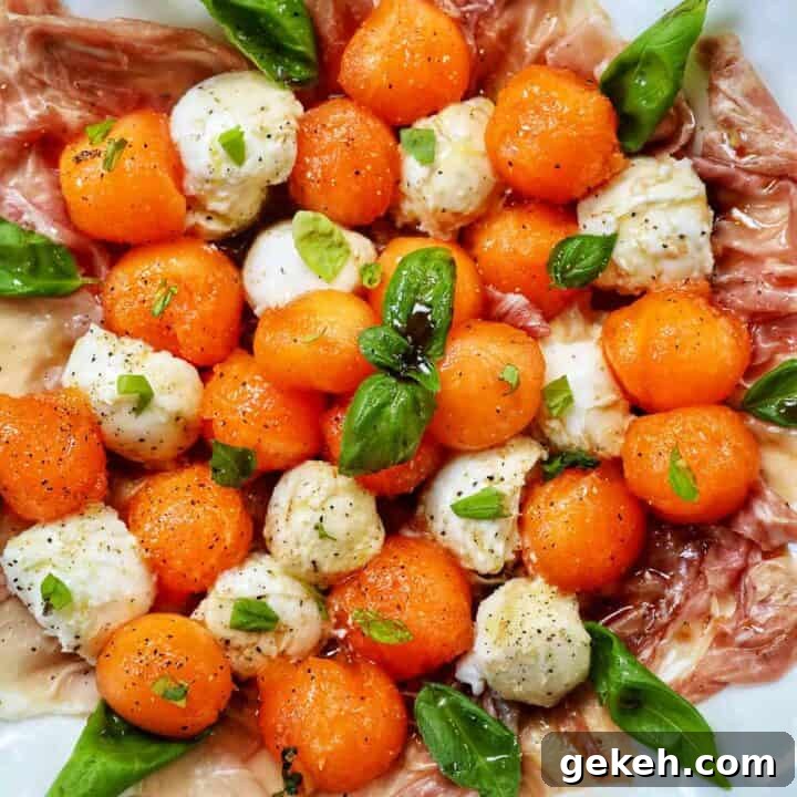 cantaloupe mozzarella prosciutto basil caprese salad on a white plate.