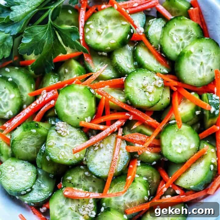 Bowl of sliced cucumbers, julienned carrots, sesame seeds, and herbs on the side.