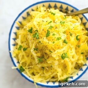 A bowl of cooked spaghetti squash garnished with fresh parsley and black pepper.