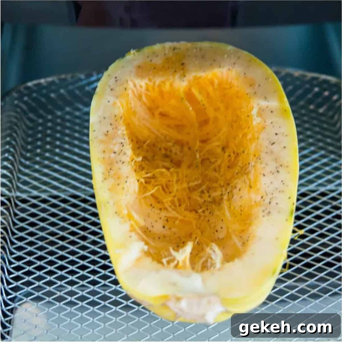 An air fryer with half of a spaghetti squash in it.
