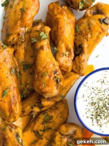 A plate of buffalo chicken wings with a side of ranch dressing.