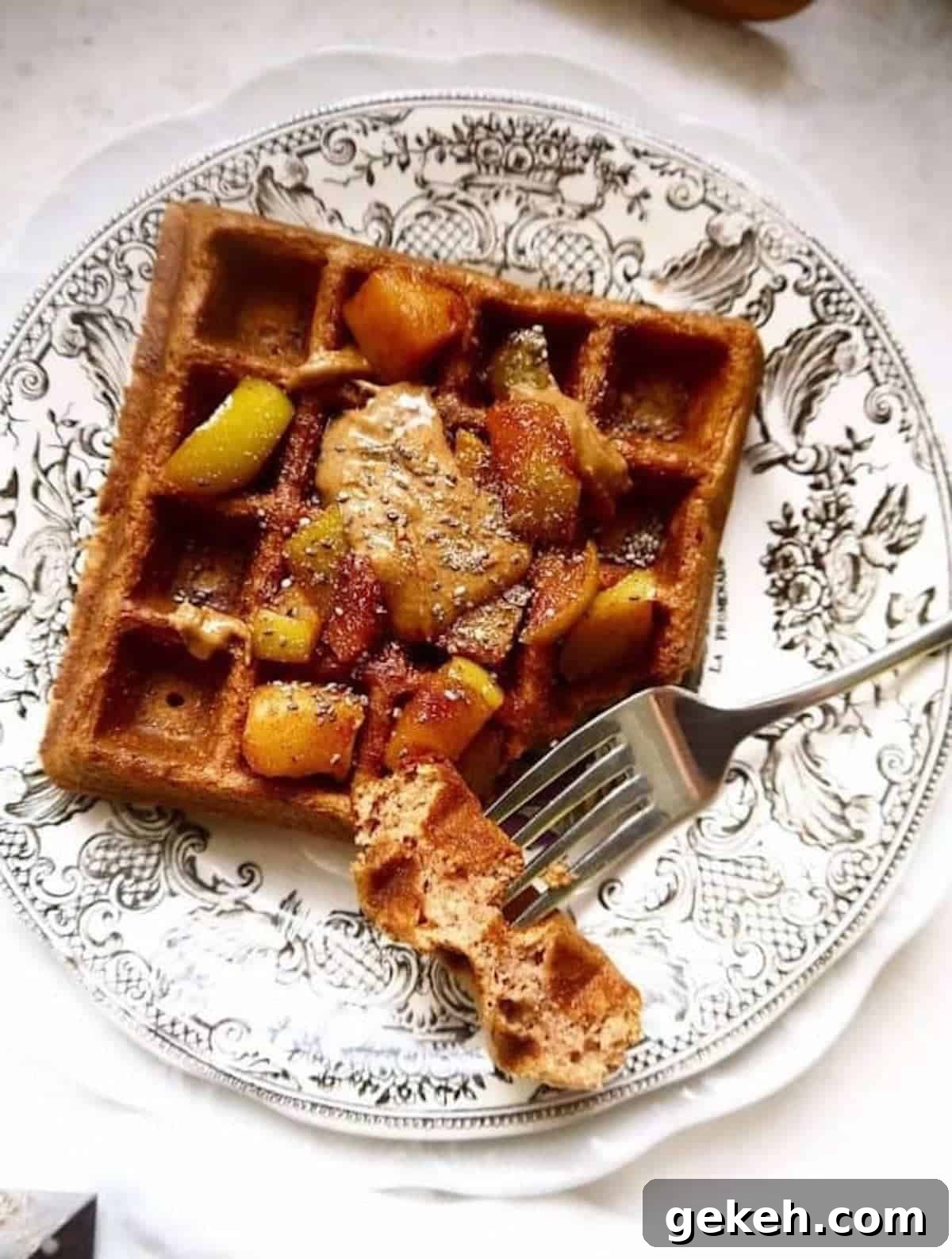 Gluten-Free Apple Cinnamon Waffles (Paleo-Friendly) 2 Apple cinnamon waffles on a plate with apples on top.