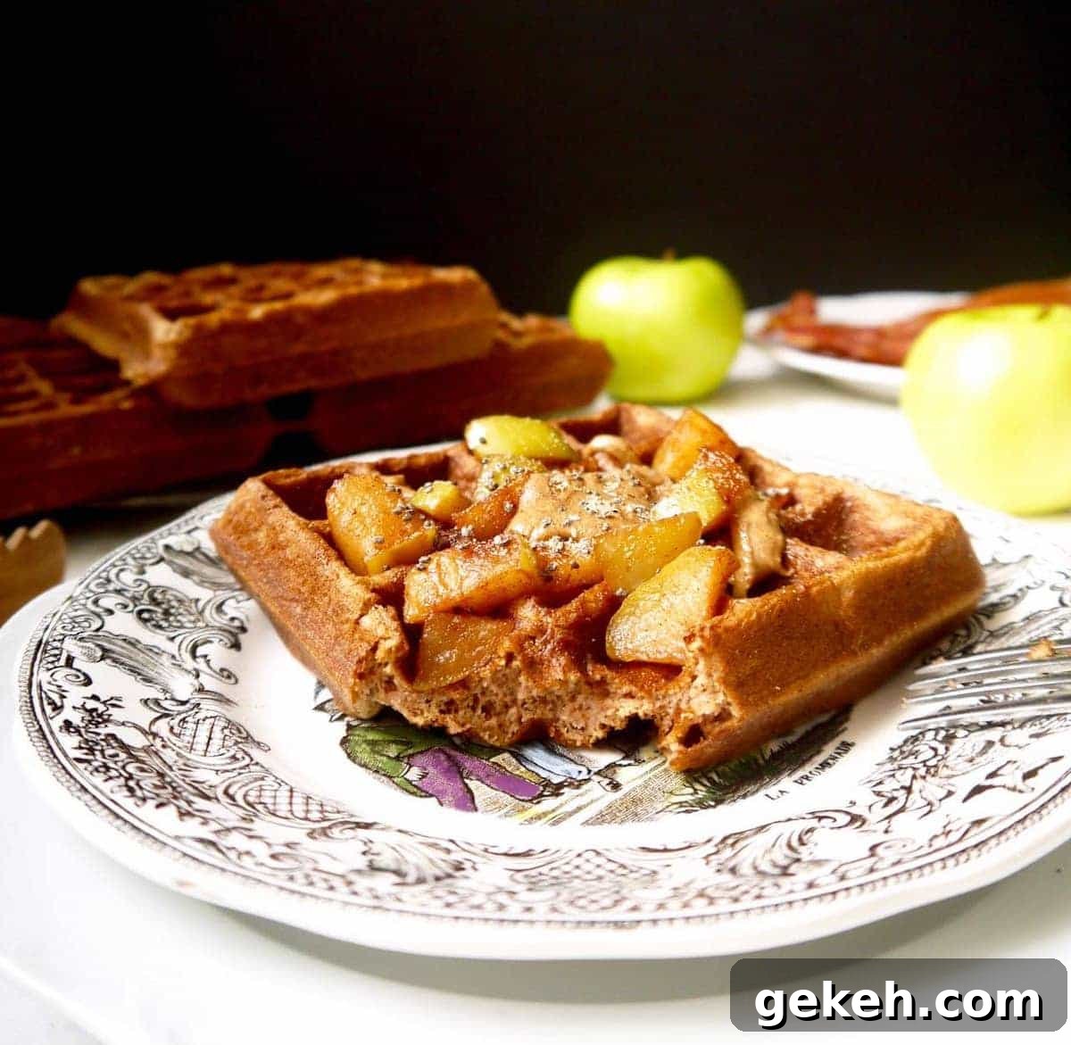 Gluten-Free Apple Cinnamon Waffles (Paleo-Friendly) 3 Gluten free apple cinnamon waffles on a plate with a bite taken out of it.