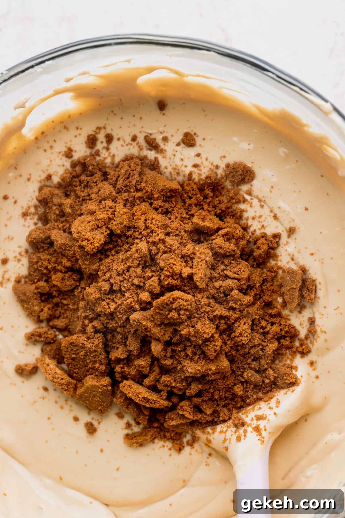 Biscoff cookie crumbs on top of cheesecake batter.