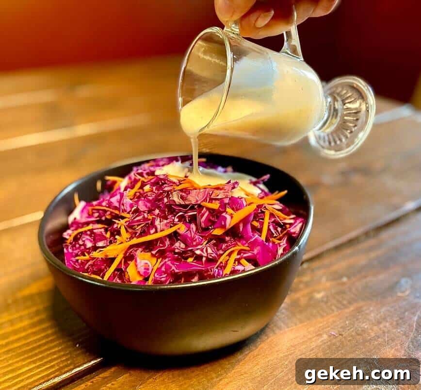 Classic Homemade Coleslaw Recipe with Creamy Tangy Dressing 7 Pouring dressing over cabbages and carrots.
