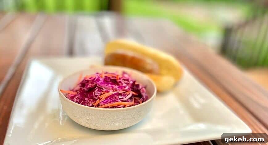 Classic Homemade Coleslaw Recipe with Creamy Tangy Dressing 8 Cole slaw in a small bowl, on a plate with a sausage sandwich.