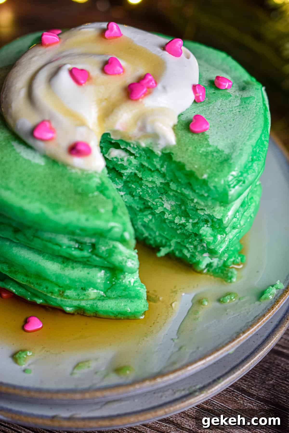 Homemade Grinch Pancakes Recipe — Green St. Patrick’s Breakfast 11 A close up of a stack of Grinch pancakes with a triangle piece cut out.