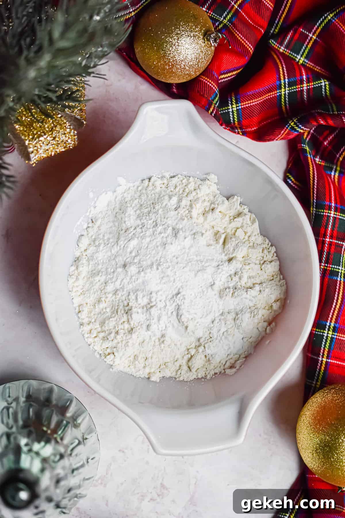 Homemade Grinch Pancakes Recipe — Green St. Patrick’s Breakfast 4 The dry ingredients are in a bowl surrounded by red plaid fabric.