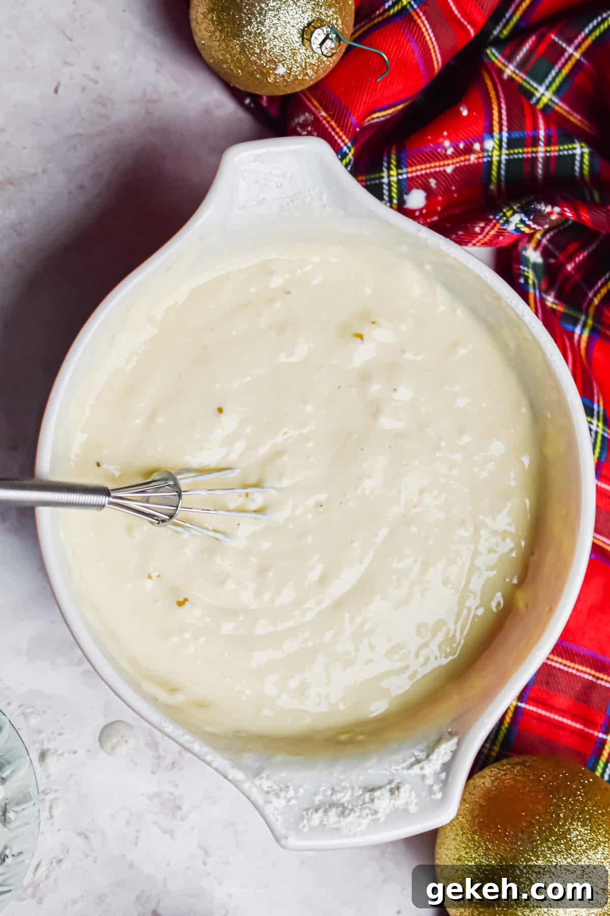 Homemade Grinch Pancakes Recipe — Green St. Patrick’s Breakfast 6 The pancake batter is in a large bowl with red plaid fabric around it.