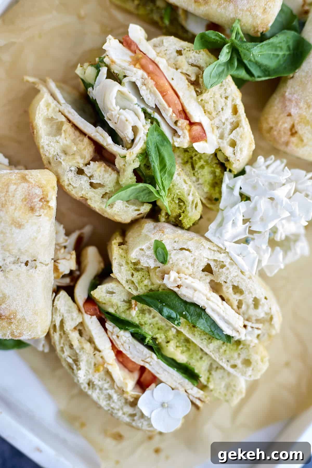 Turkey Caprese Sandwich with Fresh Mozzarella & Basil 2 overhead image of a turkey caprese sandwich sliced in half.
