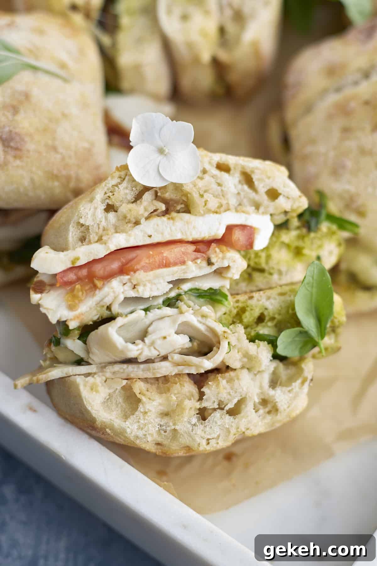 Turkey Caprese Sandwich with Fresh Mozzarella & Basil 11 a baked turkey caprese sandwich with a bite taken out.