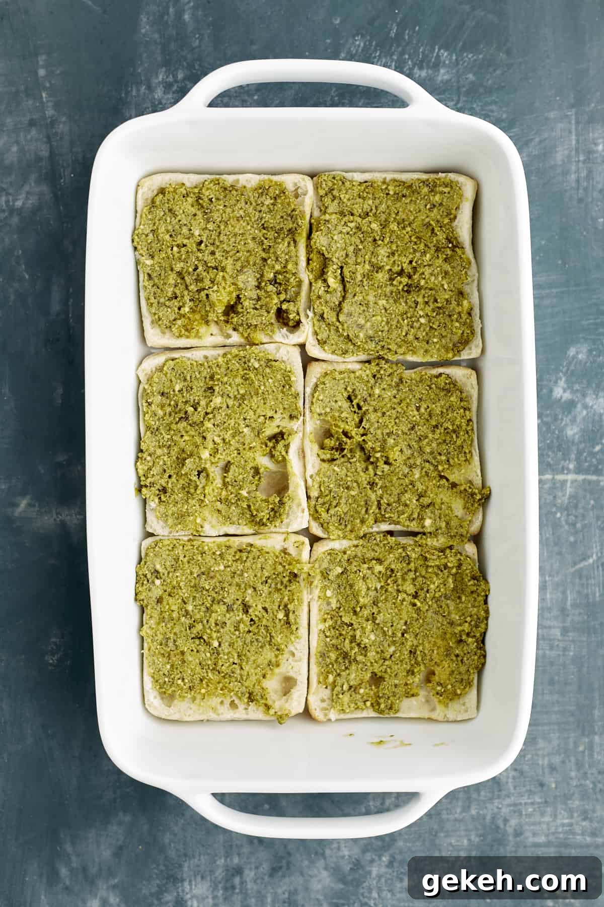 Turkey Caprese Sandwich with Fresh Mozzarella & Basil 4 sliced bread in a baking dish topped with pesto.