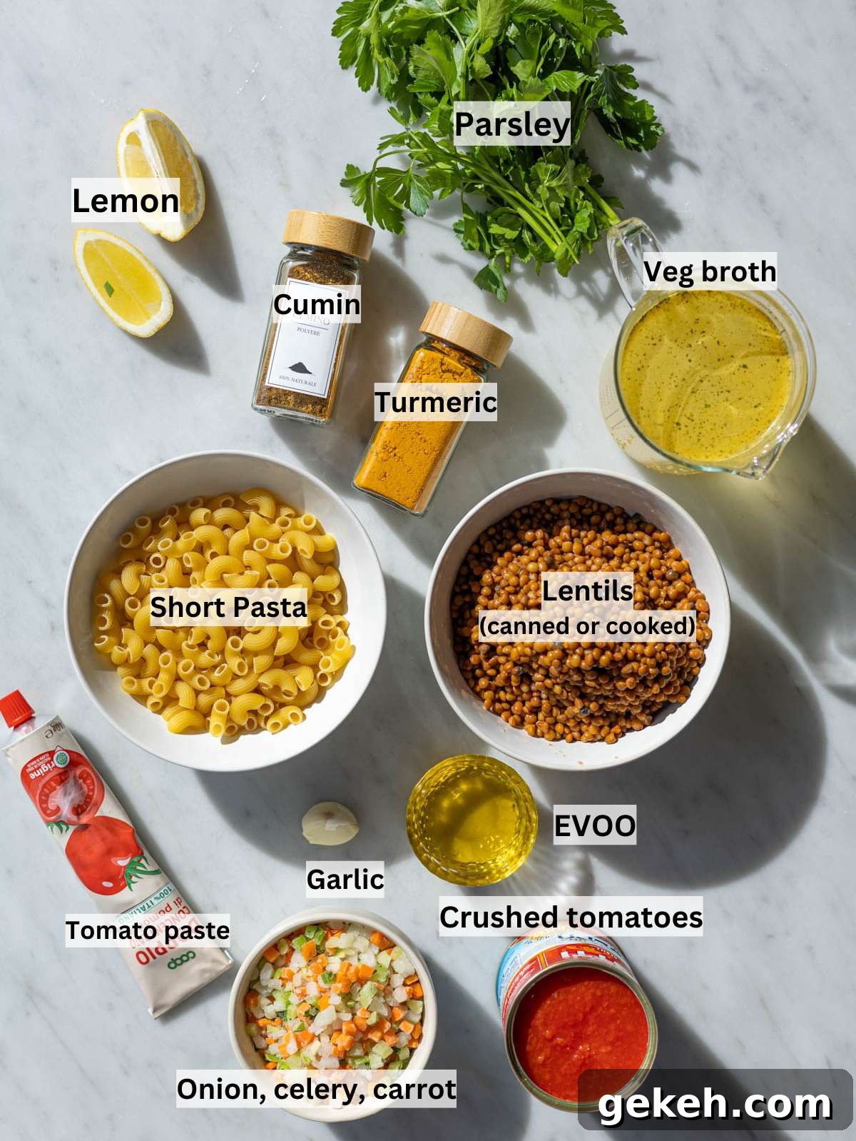 Ingredients for lentil noodle soup arranged neatly on marble kitchen table.