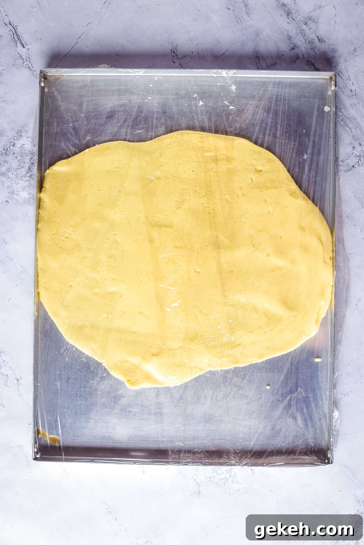 Overhead view of dough on a flat surface, after being rolled out.