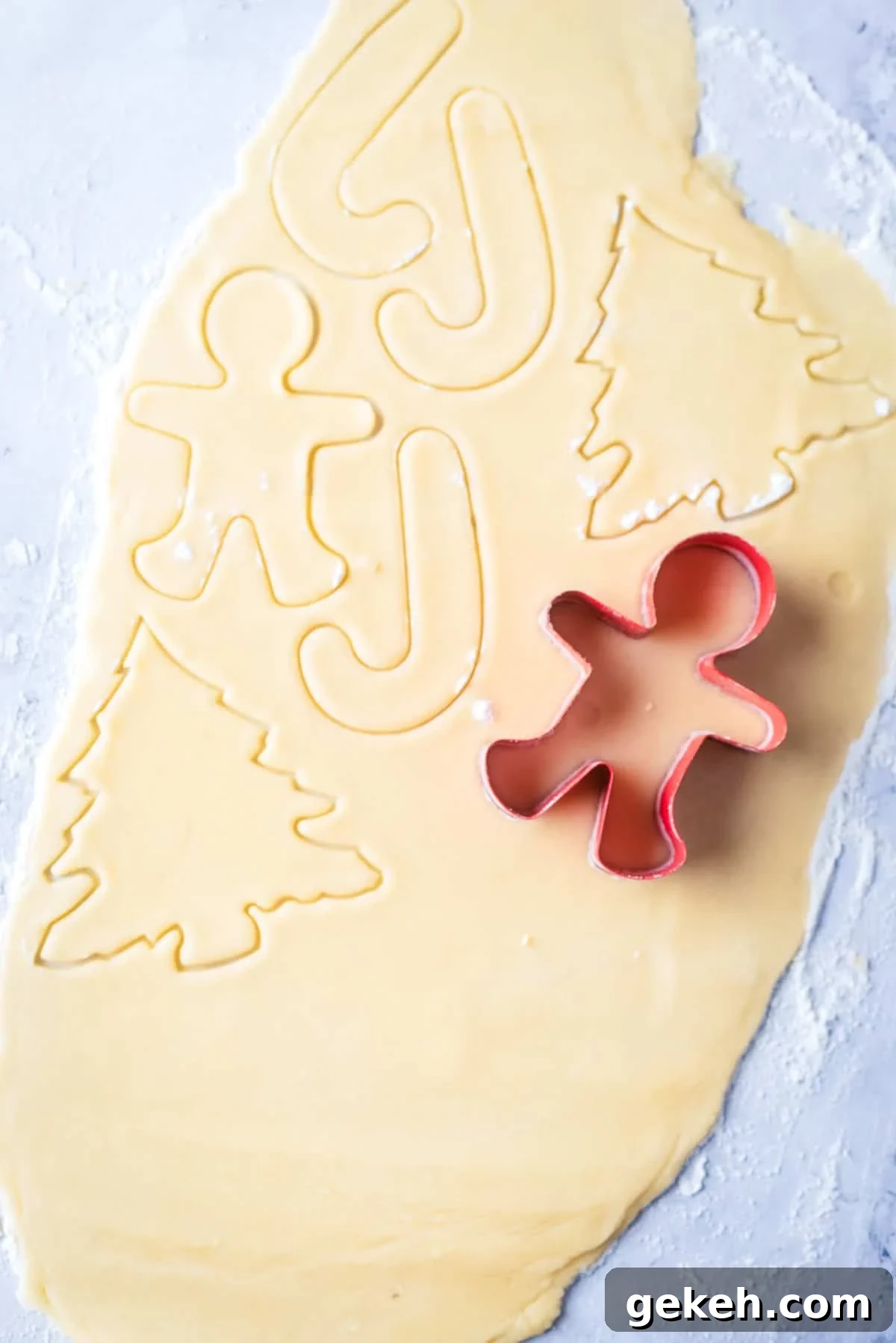 Overhead view of cookie cutter being used to press out shape in dough.