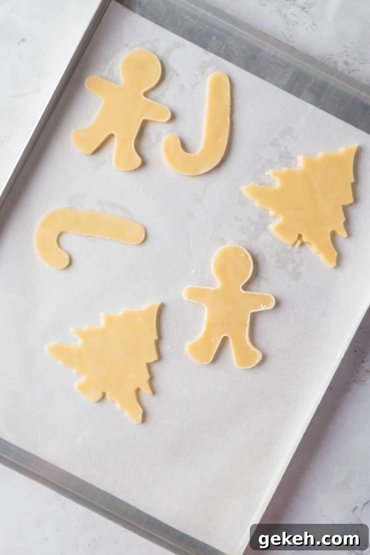 Overhead view of shapes on a parchment-lined baking sheet. 