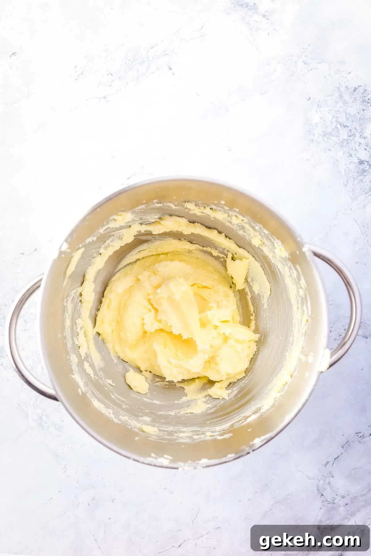Overhead view of creamed butter-sugar mixture in mixing bowl.