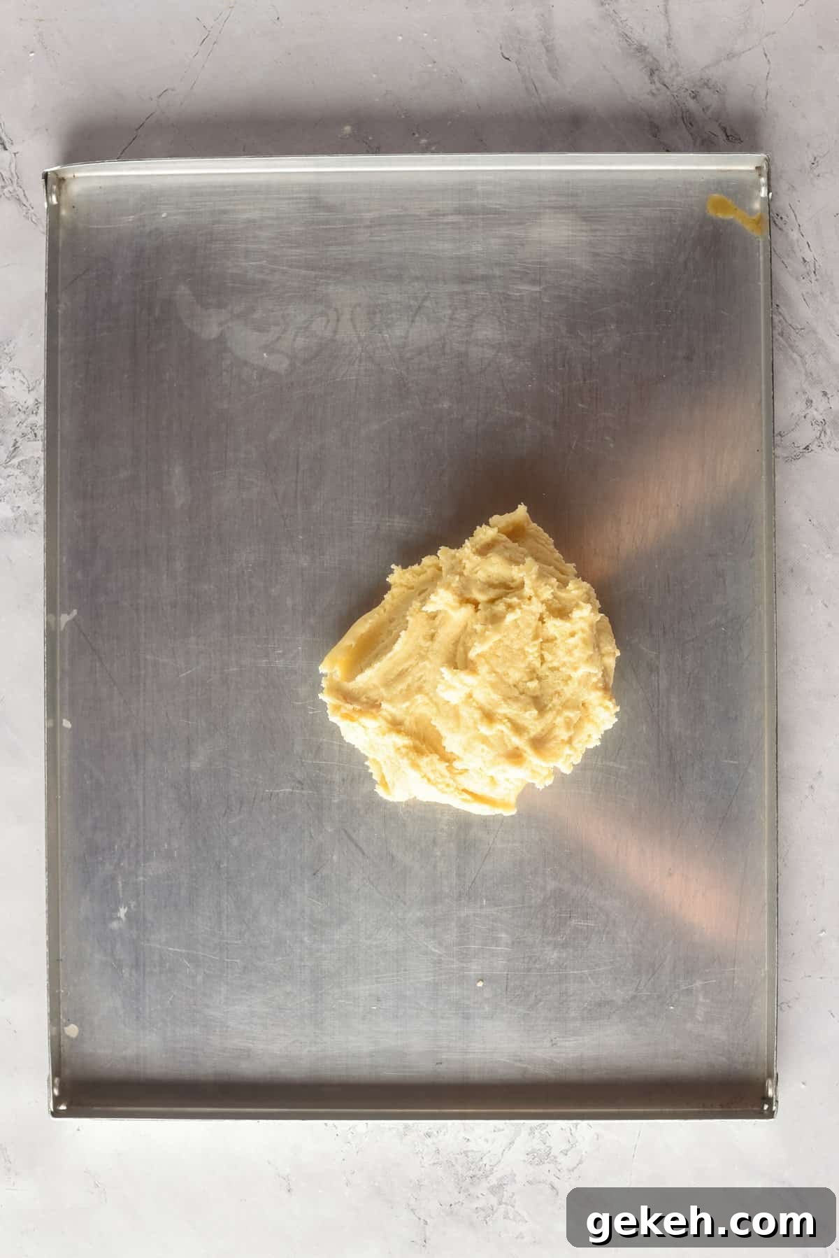 Overhead view of dough on a flat surface, before being rolled out.