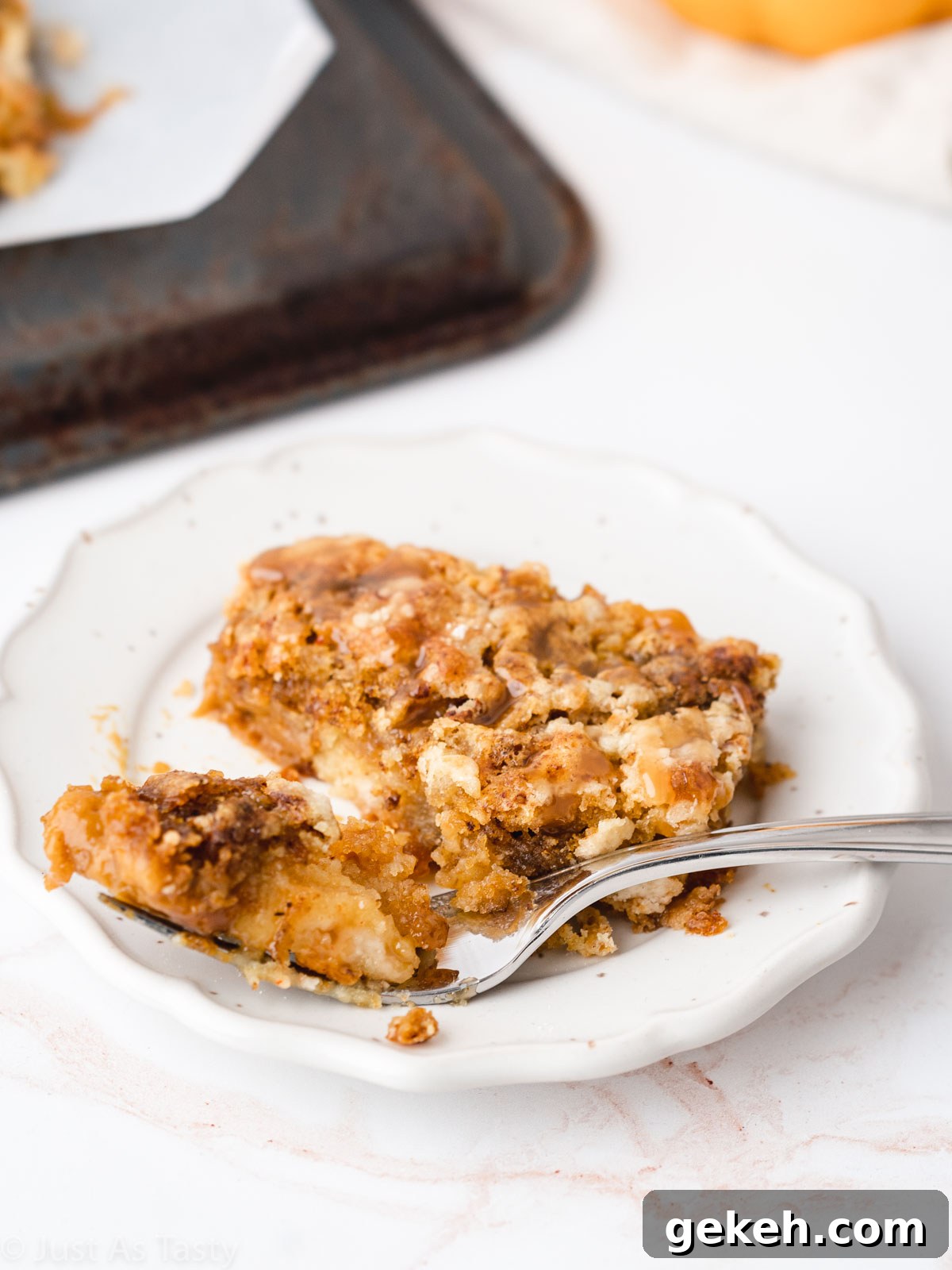 Slice of pumpkin pie dump cake on a white plate with a fork. 