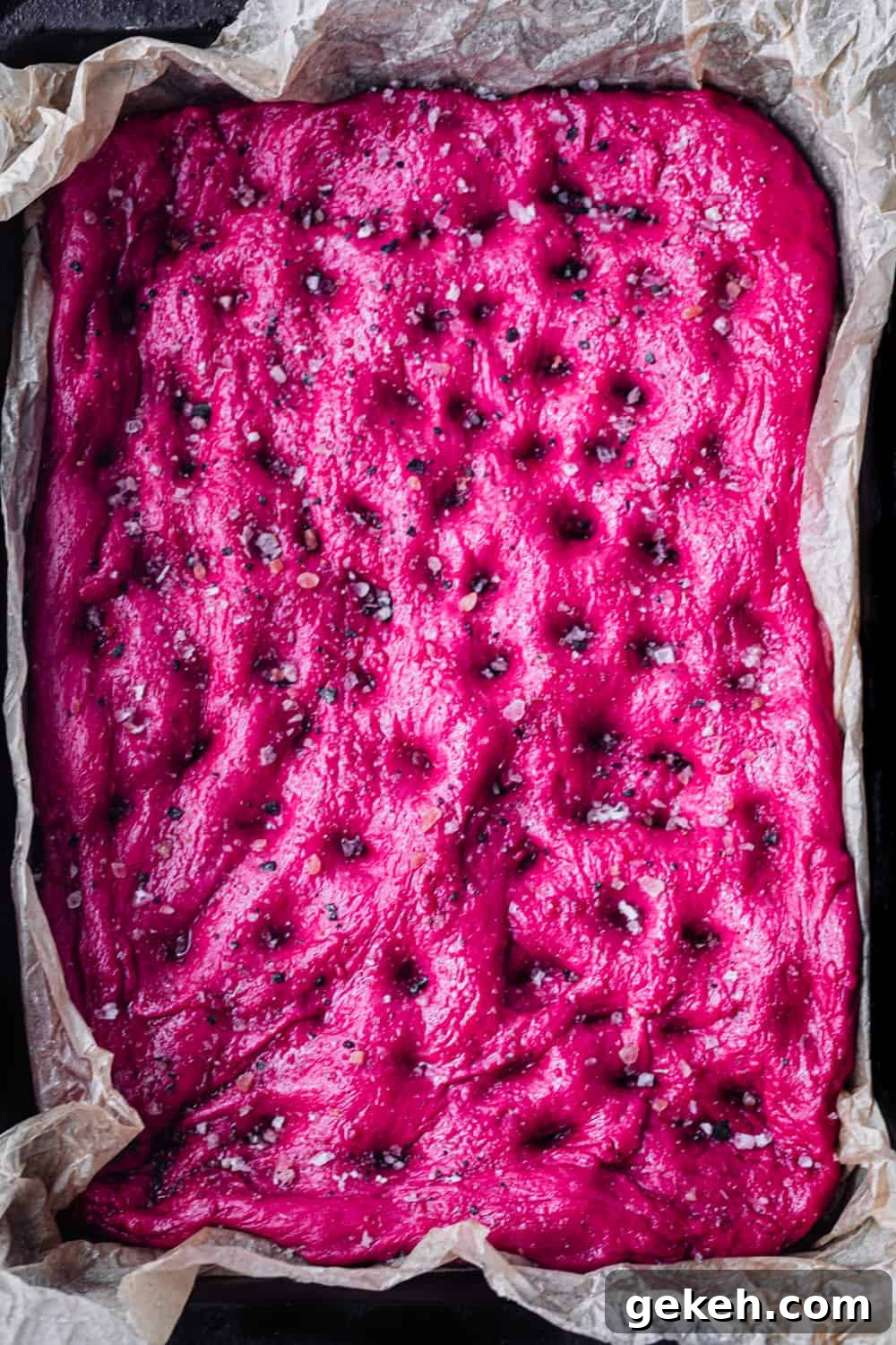 Beet Focaccia: Vibrant No-Knead Magenta Bread Recipe 4 Roasted Beet Focaccia dough on a baking pan sprinkled with salt; pre-oven and overhead shot.