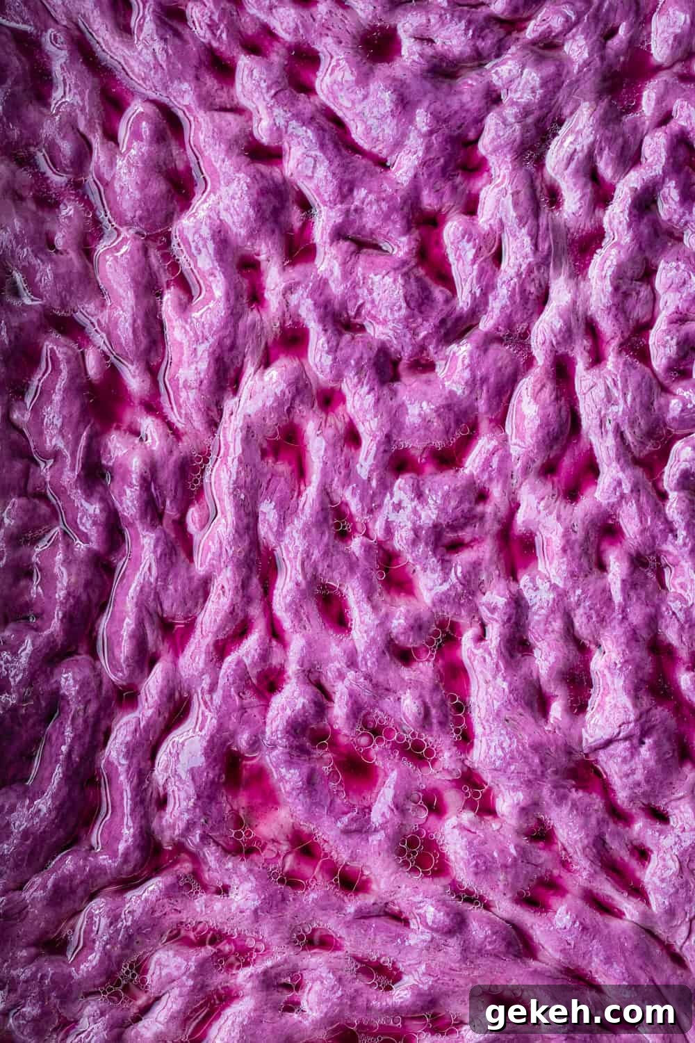 Beet Focaccia: Vibrant No-Knead Magenta Bread Recipe 6 Brining raw beet focaccia dough; overhead and unclose shot of the brine in the pink focaccia dimples.