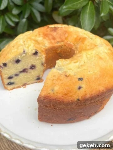 Lemon Blueberry Mascarpone Pound Cake, sliced, on a pedestal.