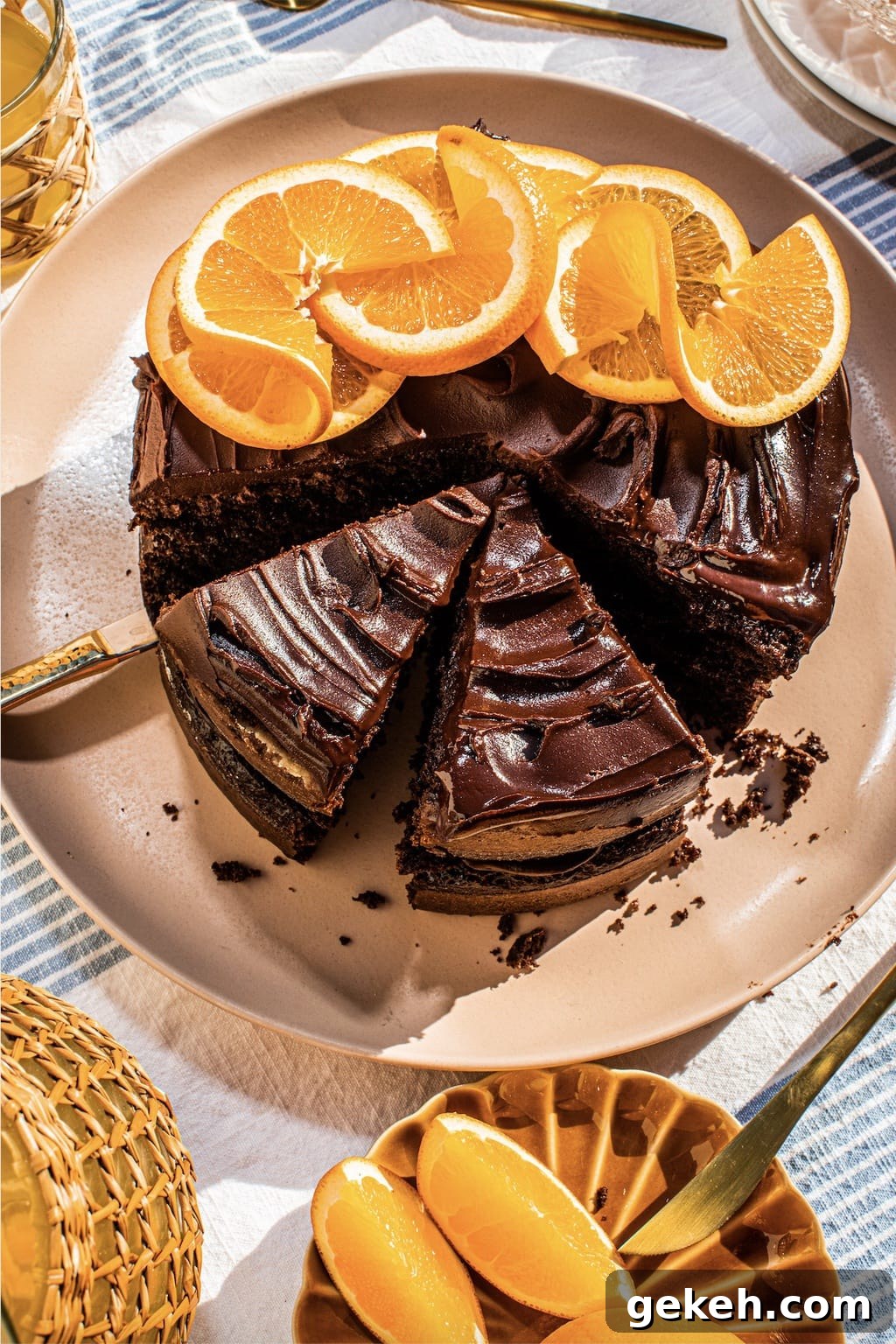 Decadent Chocolate Orange Cake Recipe 2 chocolate cake on a pink platter with oranges on top