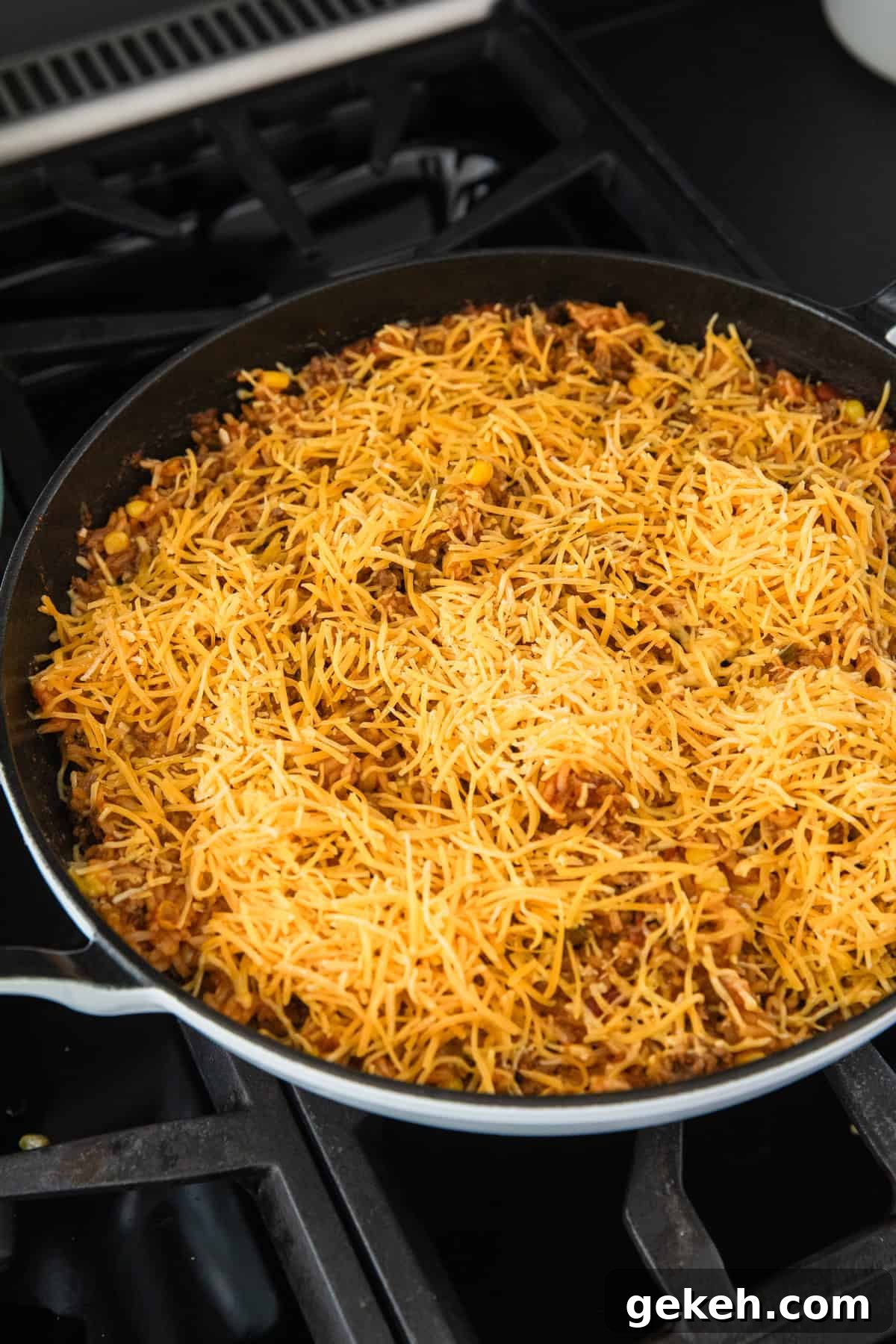 Savory Ground Beef and Salsa Rice Skillet Recipe 6 Adding shredded cheese to the cooked rice.