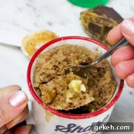 Gluten-Free Banana Mug Cake Recipe You Can Make in Minutes 6 Someone eating a gluten free mug cake with banana, almond and white chocolate