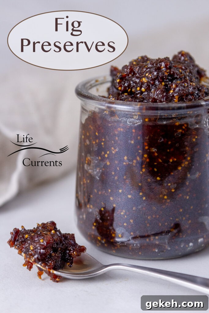 Fig Preserves in a glass jar with a spoonful of the jam in front of the jar.