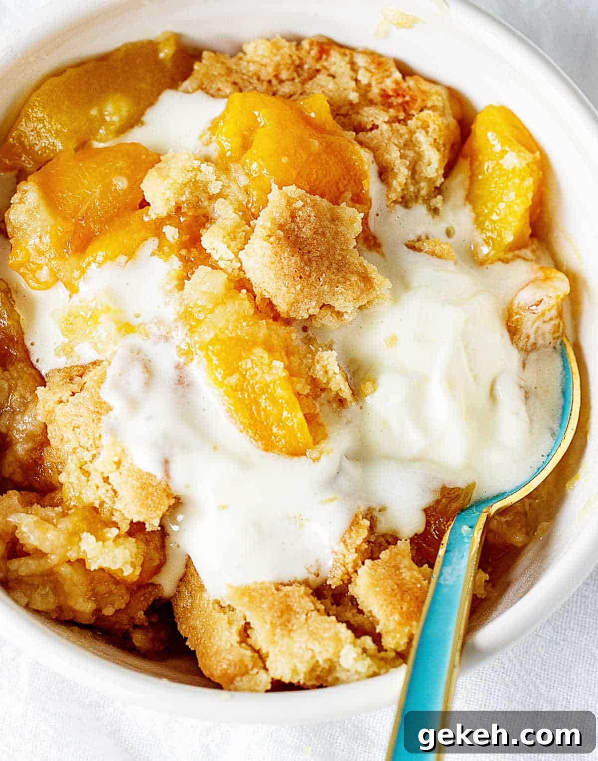 15+ Delicious Canned Peach Recipes for Every Meal 11 peach dump cake with ice cream in bowl.