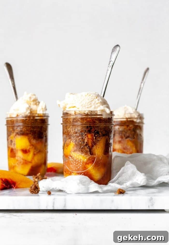 15+ Delicious Canned Peach Recipes for Every Meal 10 peach cobblers in jars with vanilla ice cream and spoons.