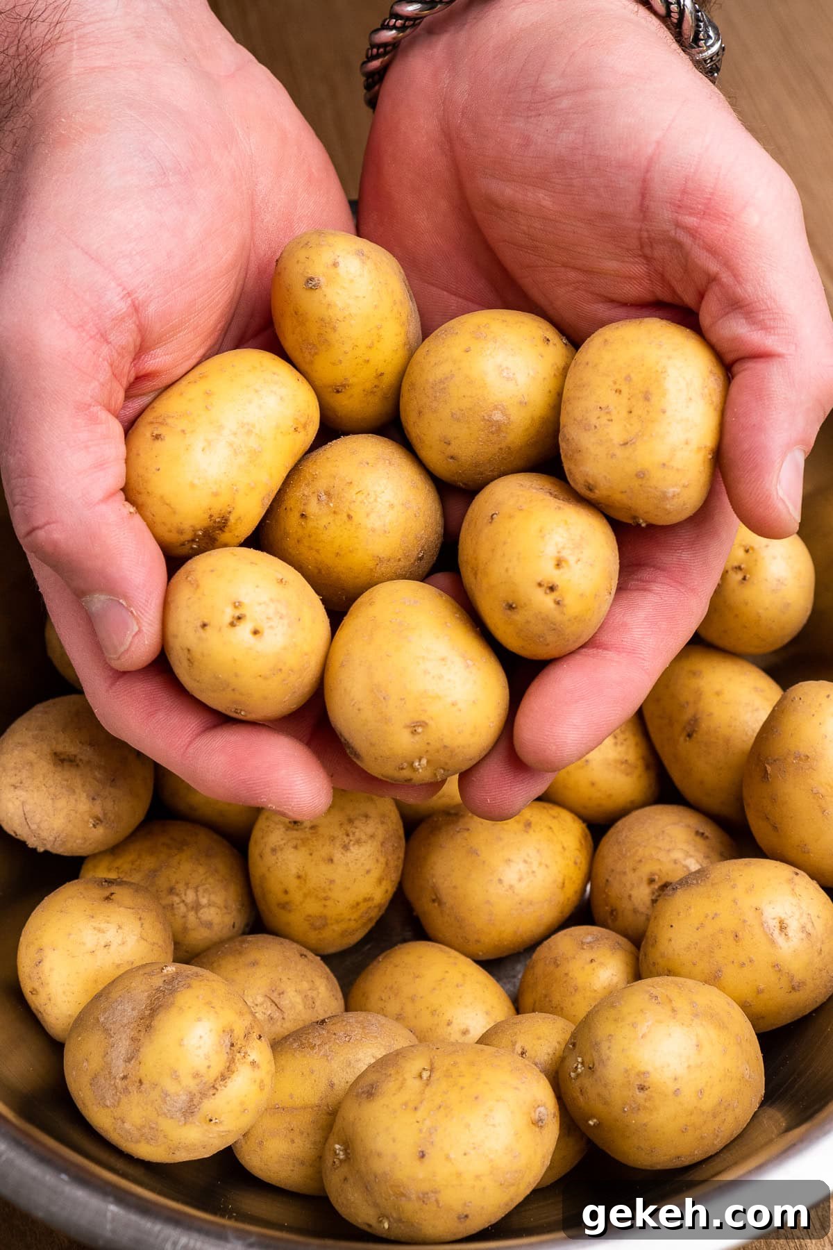 Crispy Air-Fried Baby Potatoes Recipe 12 A bowl of baby potatoes and two hands holding baby potatoes
