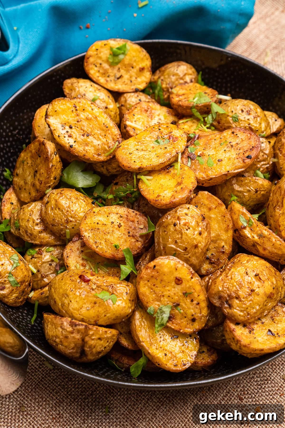 Crispy Air-Fried Baby Potatoes Recipe 3 Air Fryer Baby Potatoes served in a black bowl with fresh chopped parsley sprinkled over the top