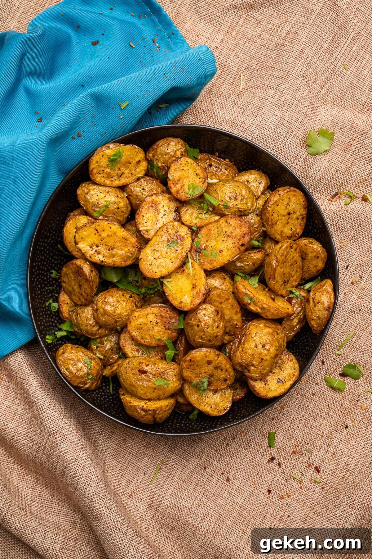 Crispy Air-Fried Baby Potatoes Recipe 20 Air Fryer Baby Potatoes served in a black bowl with fresh chopped parsley sprinkled over the top