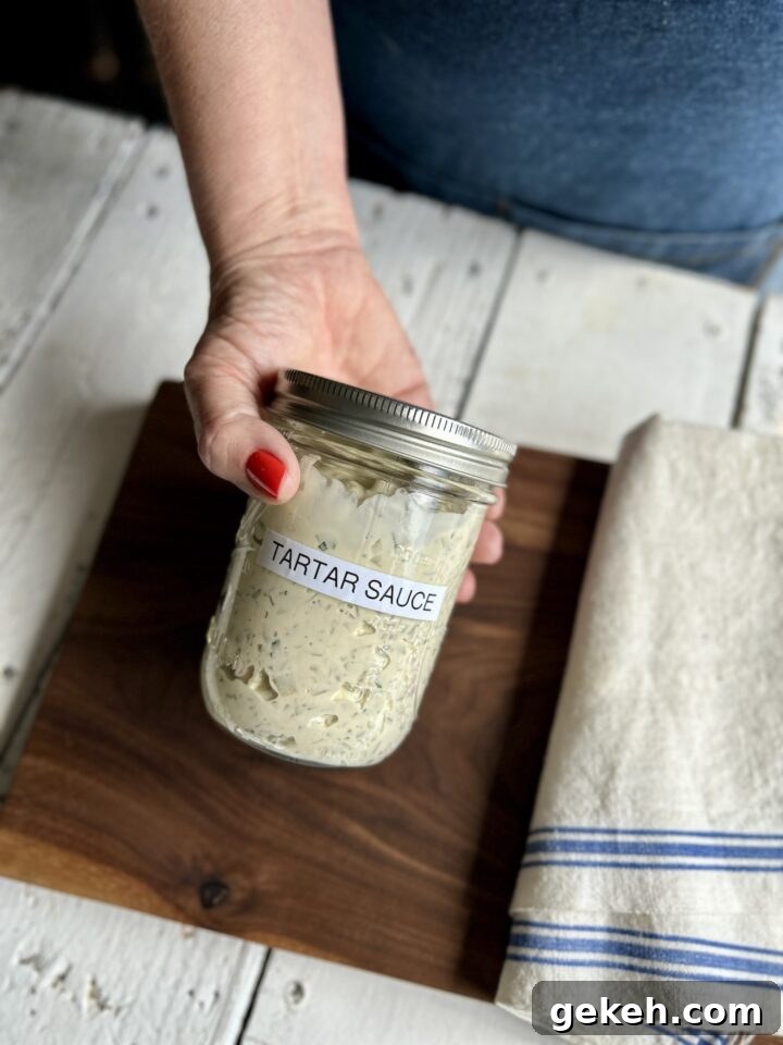 teri's hand holding jar labeled tartar sauce