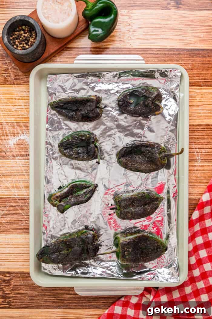 With layers of roasted poblano peppers and gooey cheese topped with fluffy eggs, this Chile Relleno Casserole is easy & flavorful. Roasted poblano peppers on a baking sheet