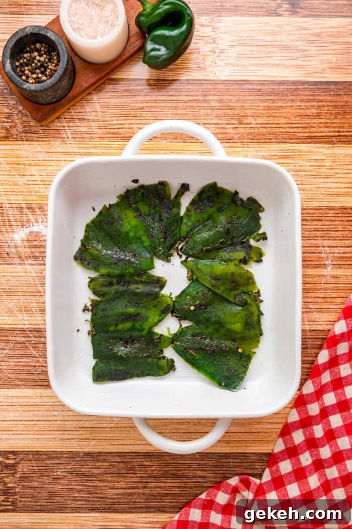 With layers of roasted poblano peppers and gooey cheese topped with fluffy eggs, this Chile Relleno Casserole is easy & flavorful. Poblano peppers in the bottom of a baking dish