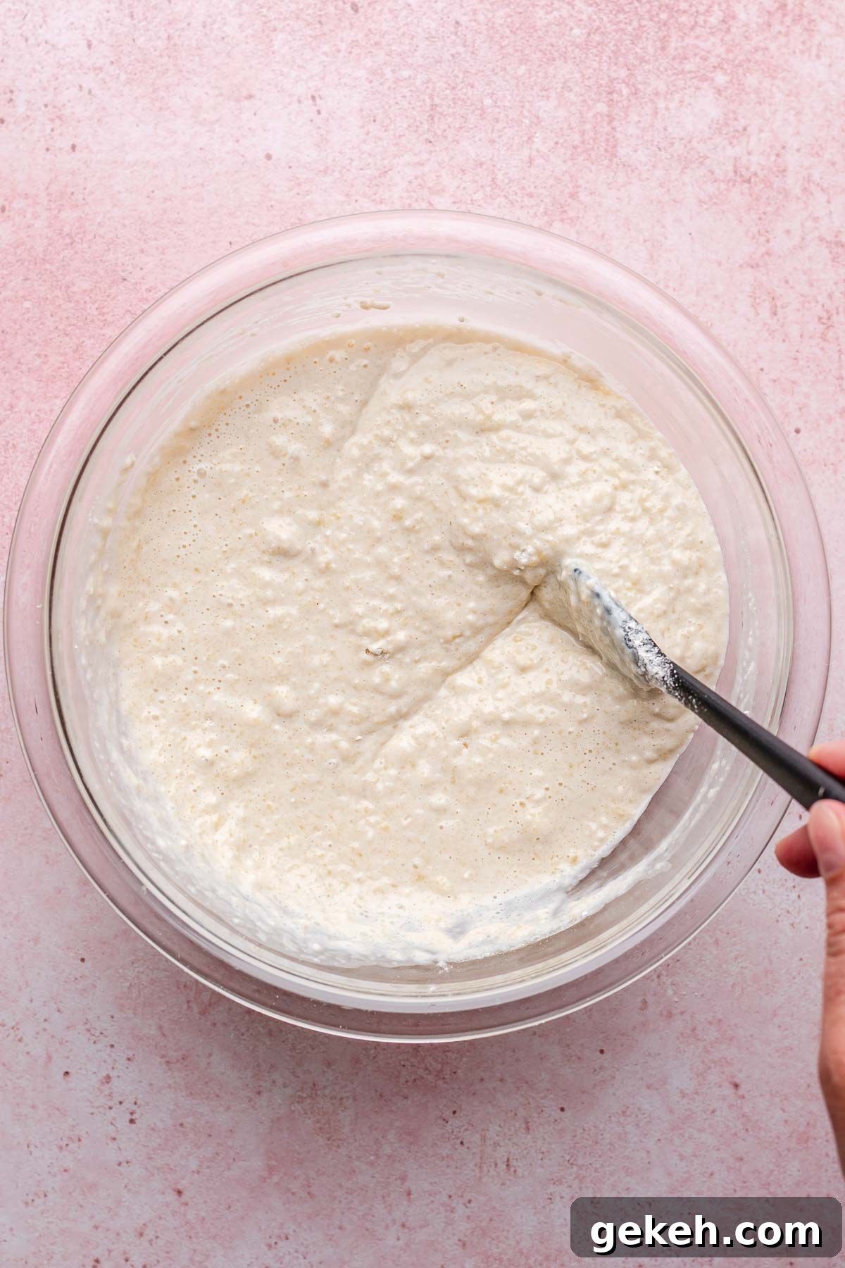Strawberry Rhubarb Cobbler Recipe: Classic Summer Dessert 5 A hand mixes bisquick batter with a rubber spatula.