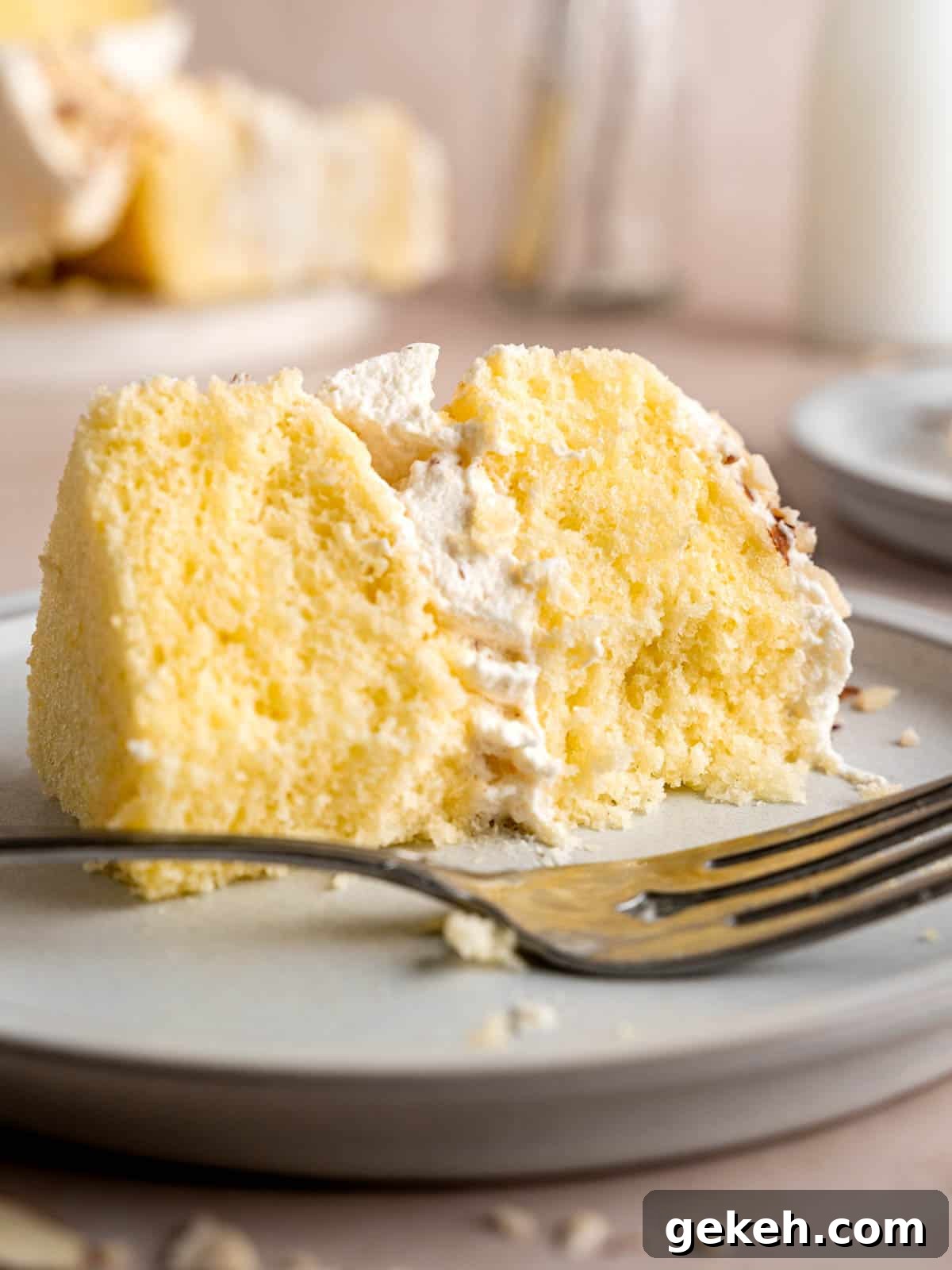 Homemade Almond Cream Cake Recipe for Moist, Decadent Slices 2 A slice of almond cream cake on a plate with a fork.