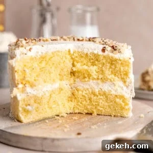 Homemade Almond Cream Cake Recipe for Moist, Decadent Slices 14 Almond cream cake on a cake stand with slices taken out of it.