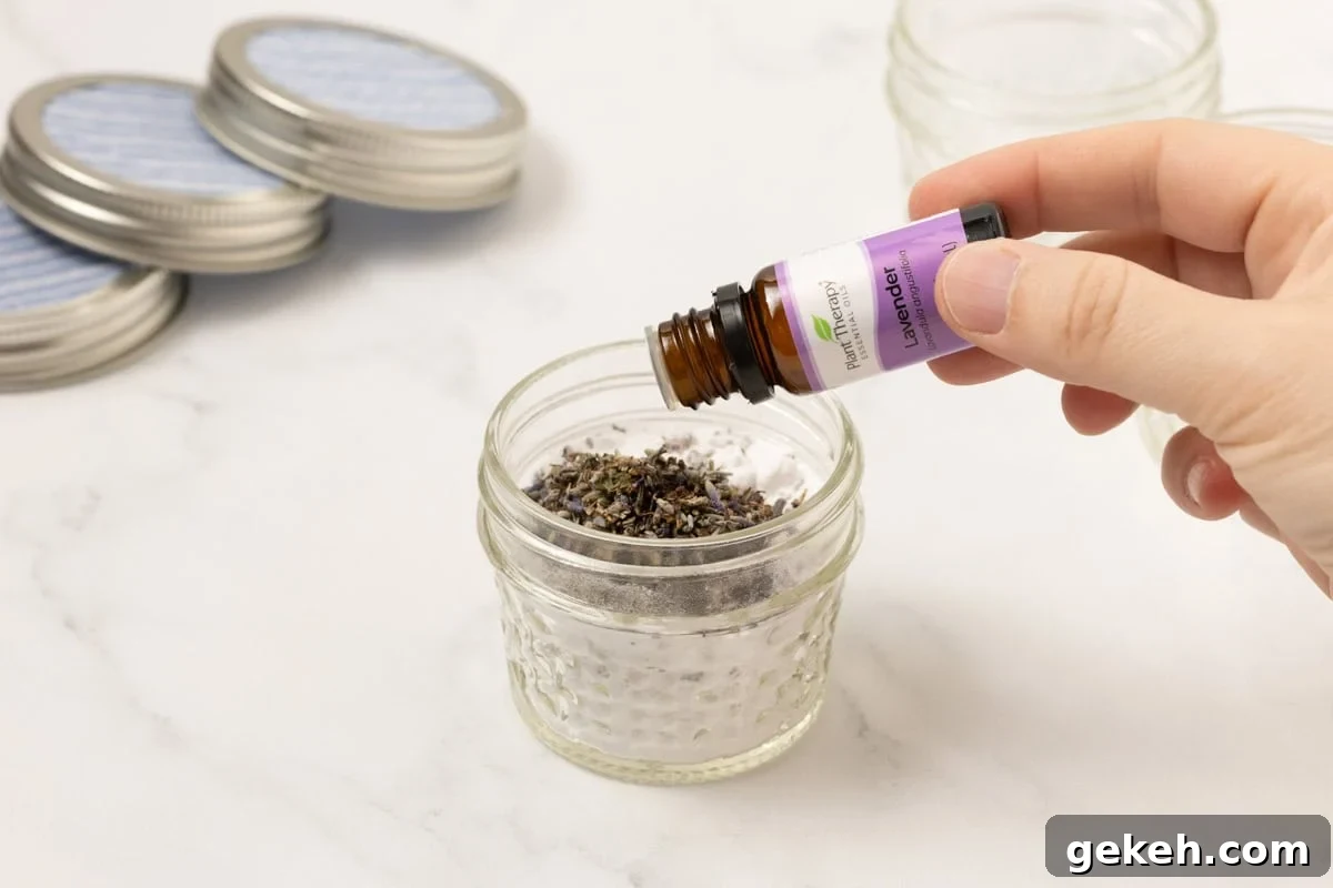 DIY Baking Soda Air Freshener with Natural Scents 4 lavender essential oil being added to baking soda and lavender buds in a mason jar