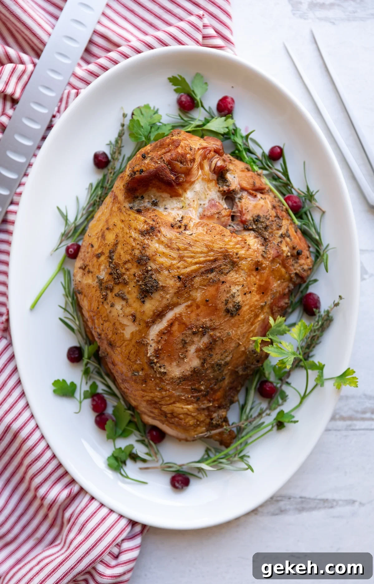 Seasoned turkey breast on platter, knife and fork on counter.