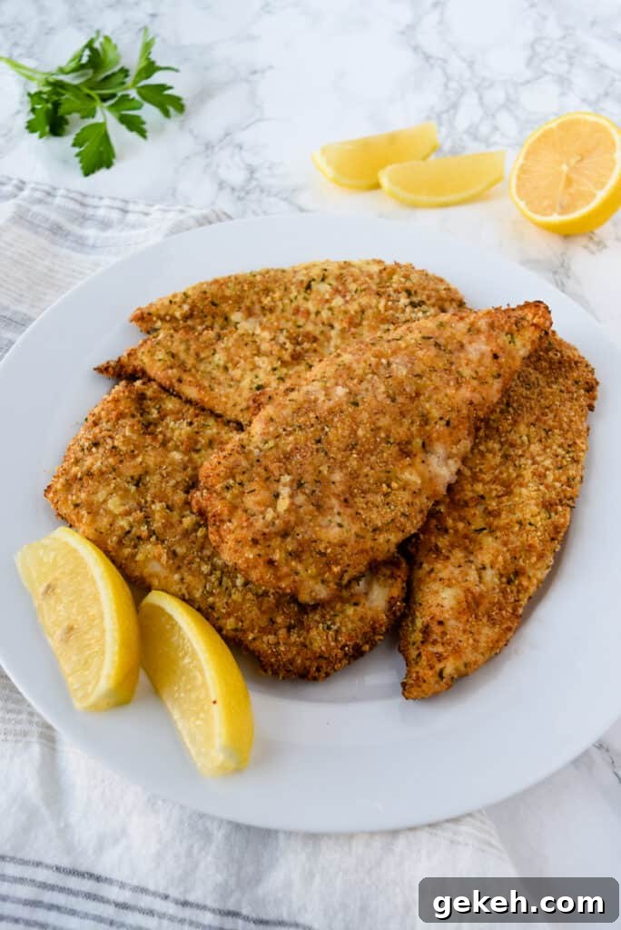 Air Fryer Parmesan Crusted Chicken on a Plate with Lemon Slices