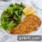 Air Fryer Parmesan Crusted Chicken on a white plate with a salad.