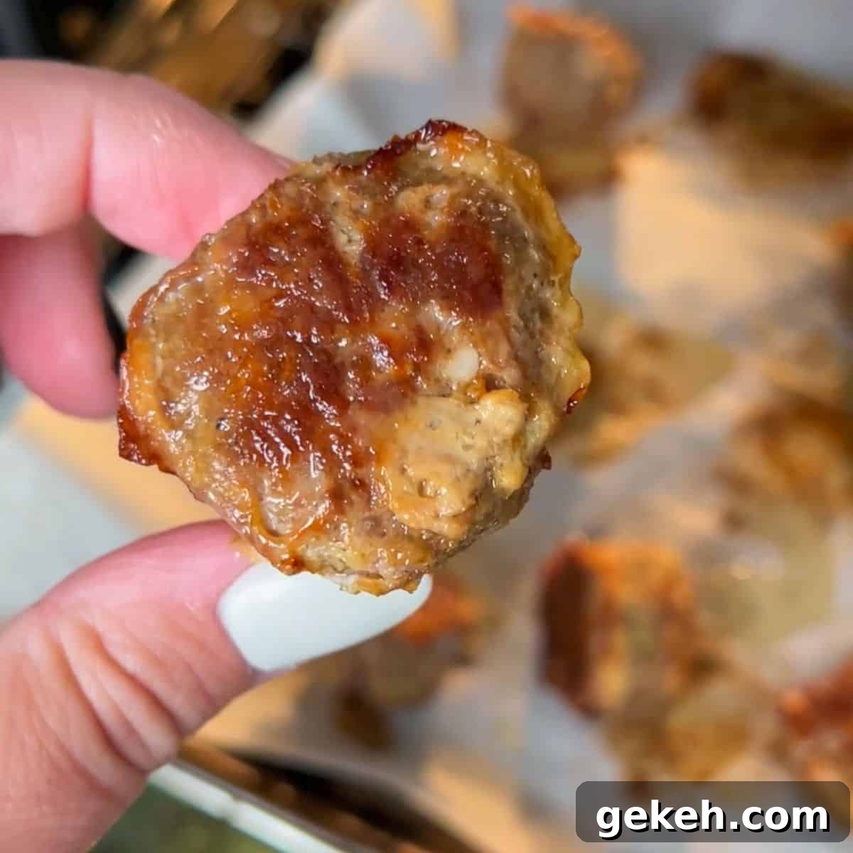 Hawaiian Roll Meatball Sliders with Tangy Pineapple Glaze 3 up close image of meatballs baking on a baking sheet.